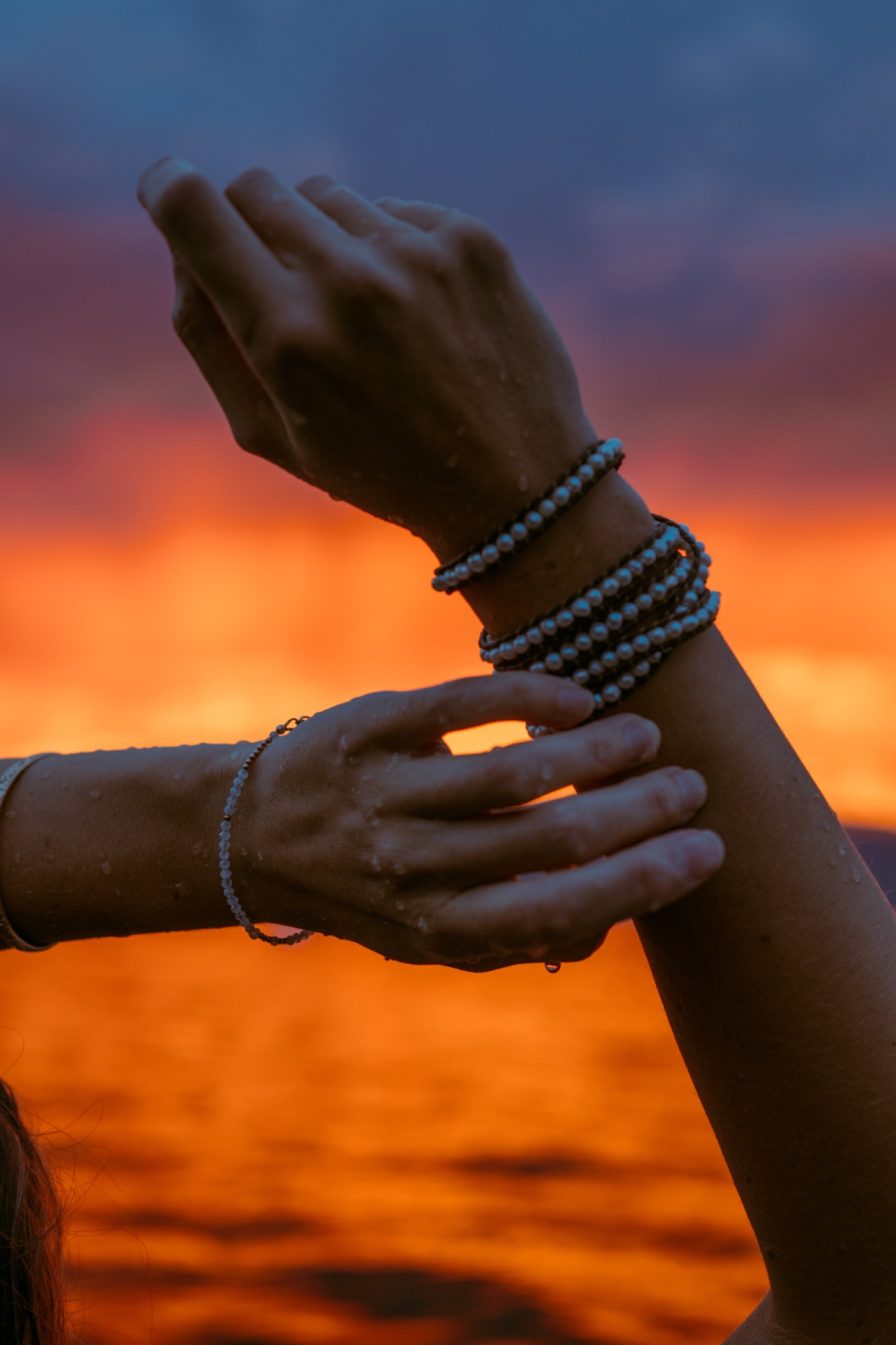 Sunset and hands over water