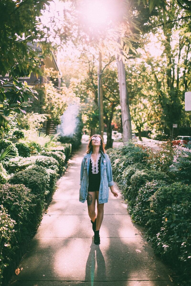 A person walks through a green Vancouver garden path filled with fern light and soft summer shade. print option