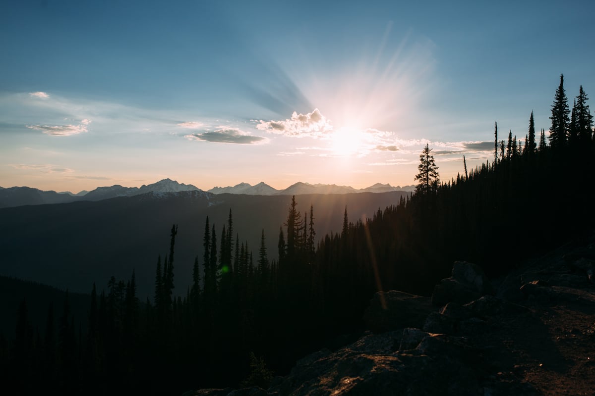 Sunlight breaks over layered ridges and dark trees in Mount Revelstoke. print option