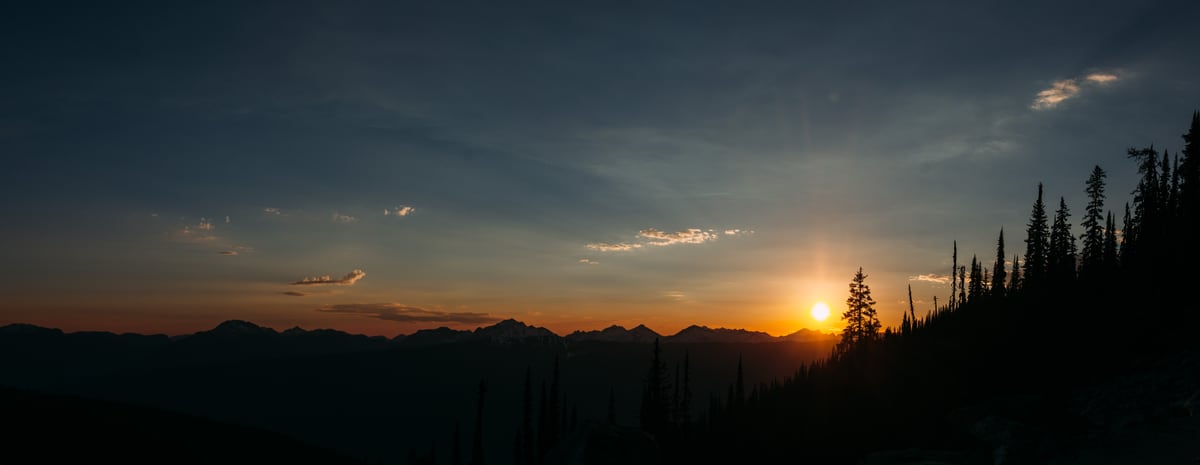 A long last-light mountain panorama with silhouetted Revelstoke trees. print option