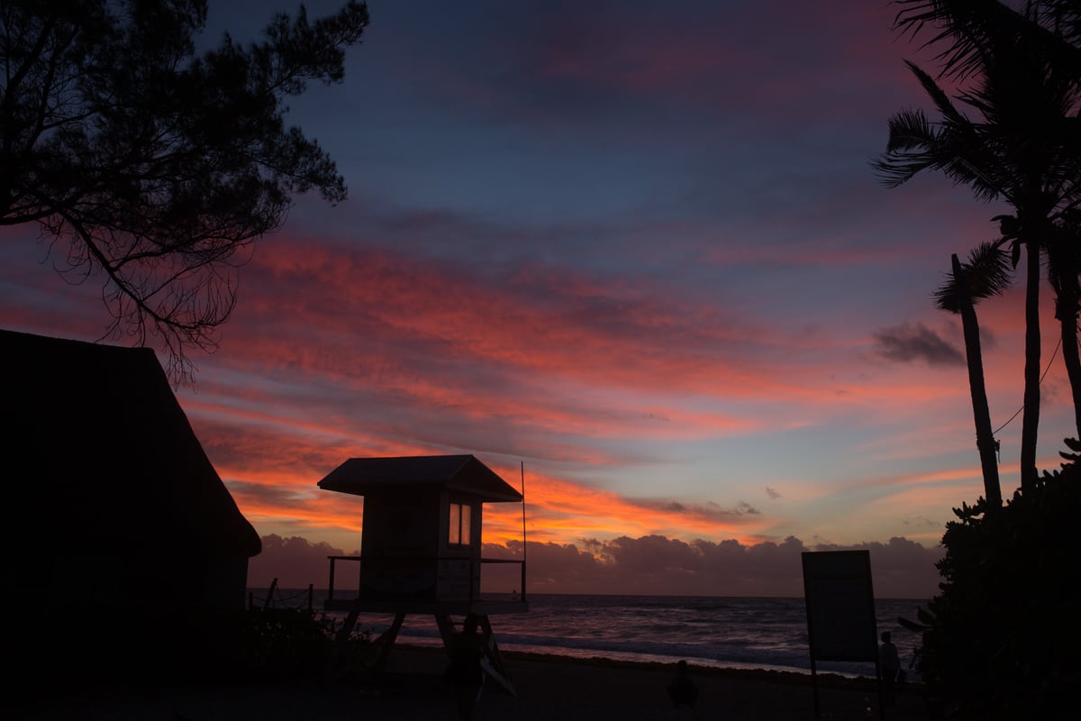 A Miami beach lifeguard hut silhouetted against red-purple sunset. print option