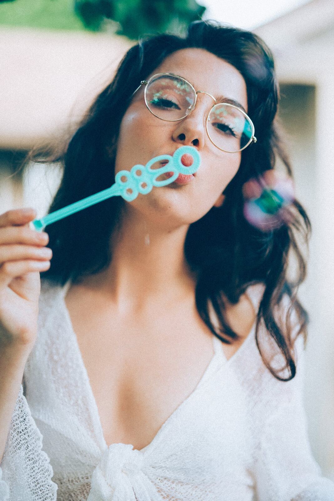 Mel in Reeds and Warm Dusk story frame 4: Bubbles, lake edge, reeds, glasses and dusk colour from a playful portrait story.