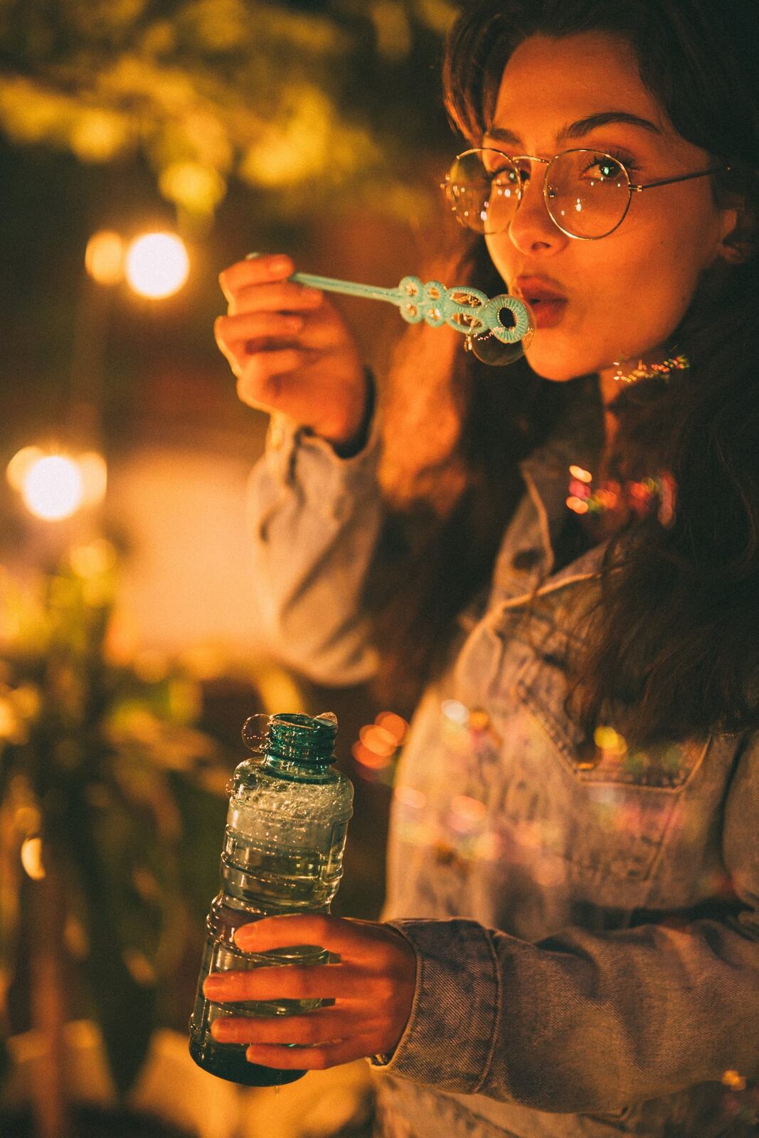 Mel in Reeds and Warm Dusk story frame 20: Bubbles, lake edge, reeds, glasses and dusk colour from a playful portrait story.
