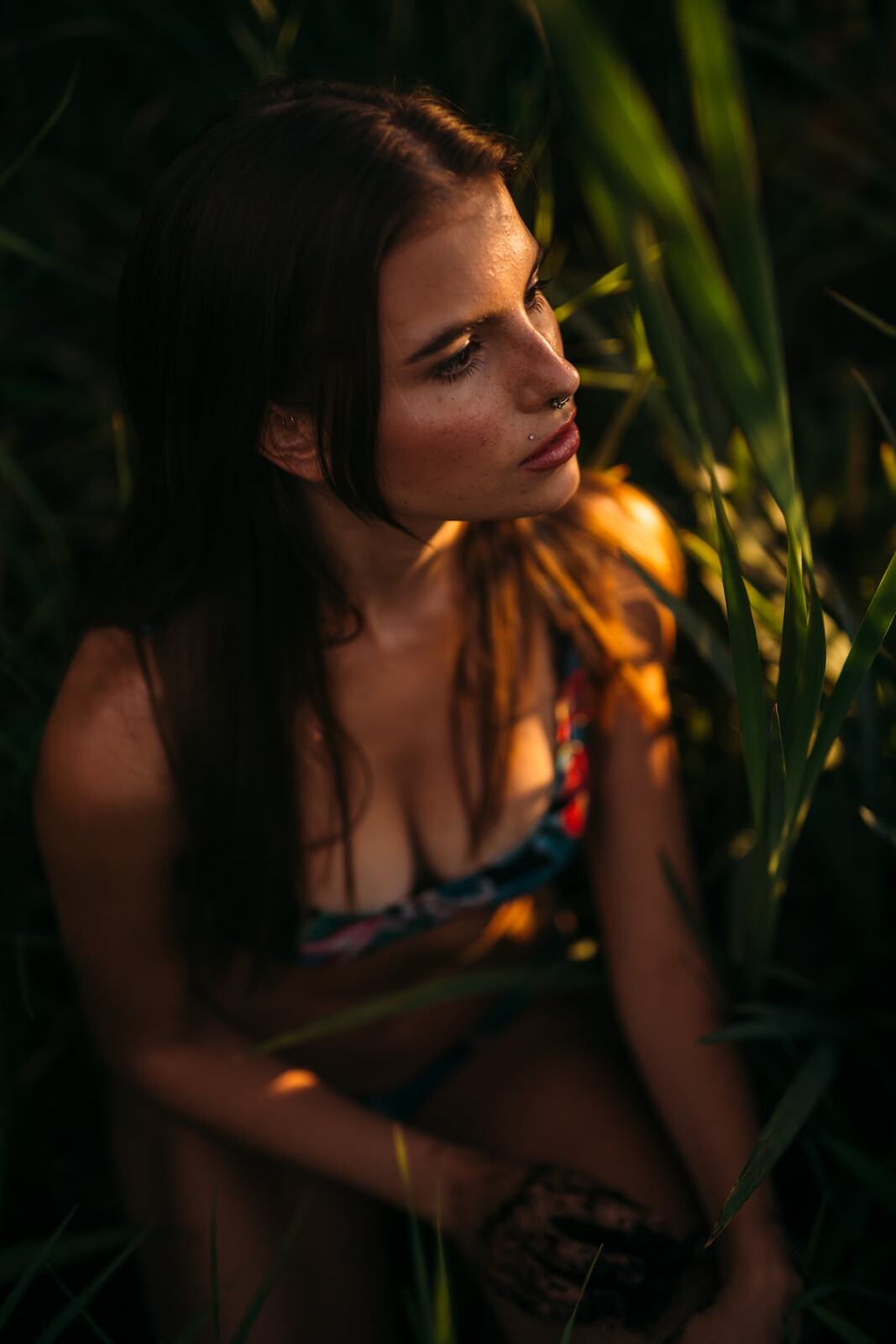 Mo in the Reeds story frame 3: Green shadow, tall grass, body paint and a charged quiet that stays grounded in portrait atmosphere.