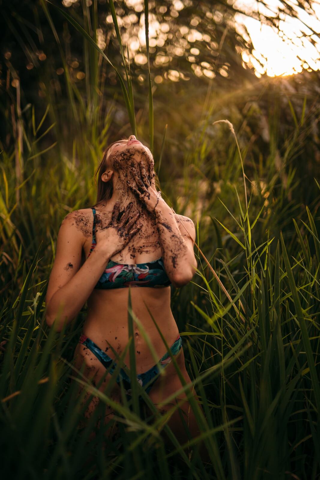 Mo in the Reeds story frame 6: Green shadow, tall grass, body paint and a charged quiet that stays grounded in portrait atmosphere.