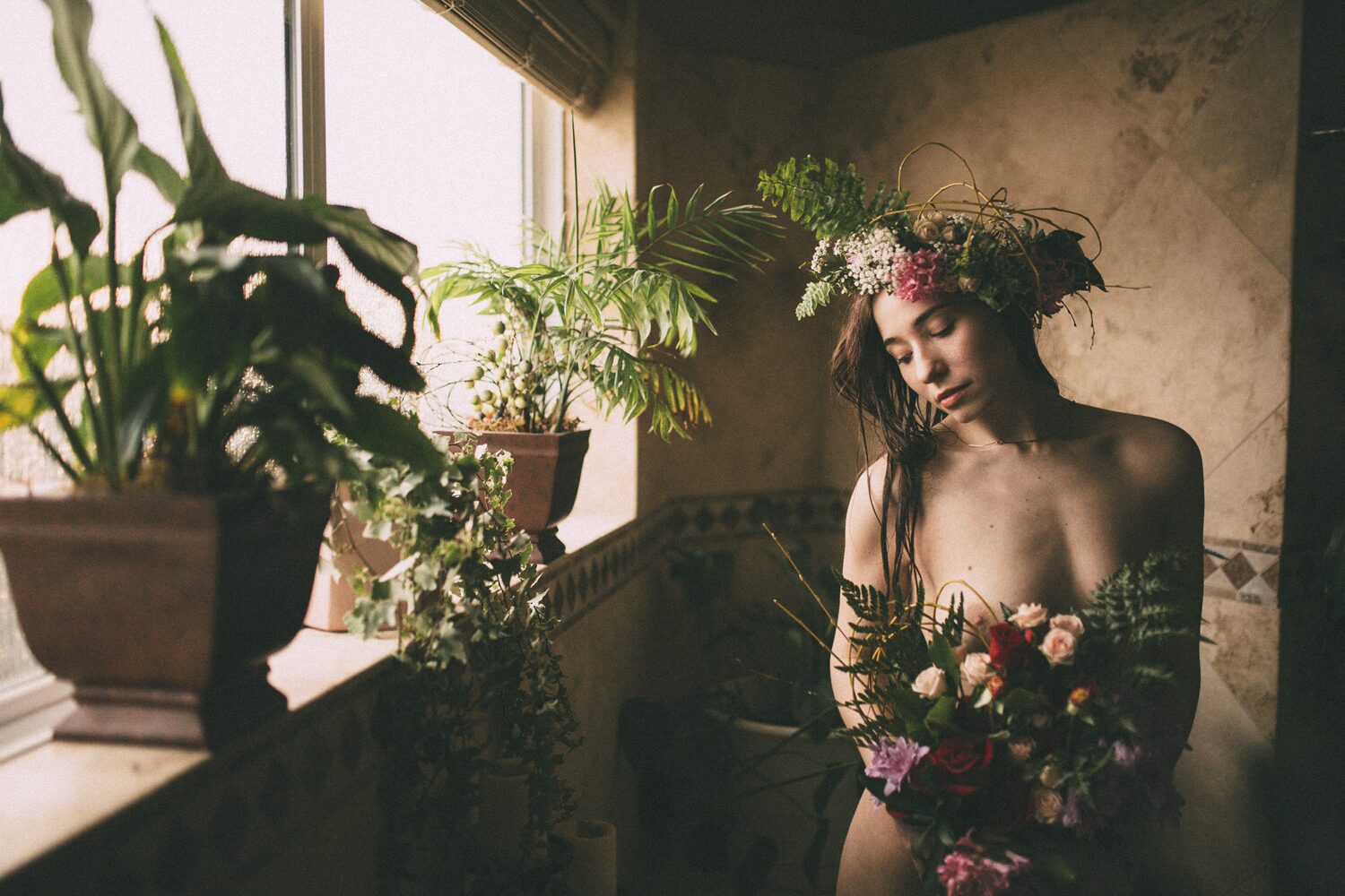 Bailey framed by window light and full florals beside the bath
