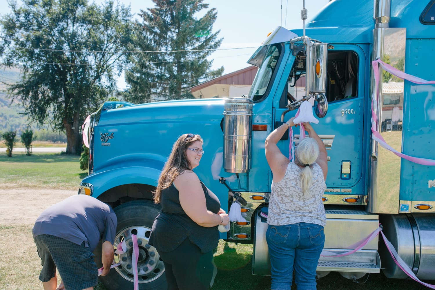 Barbara and Ryan weddings story frame 5: A Salmon Arm wedding near Mount Ida, moving from a private yard to Marine Peace Park and wharf portraits, with the groom's trucking life part of the story..