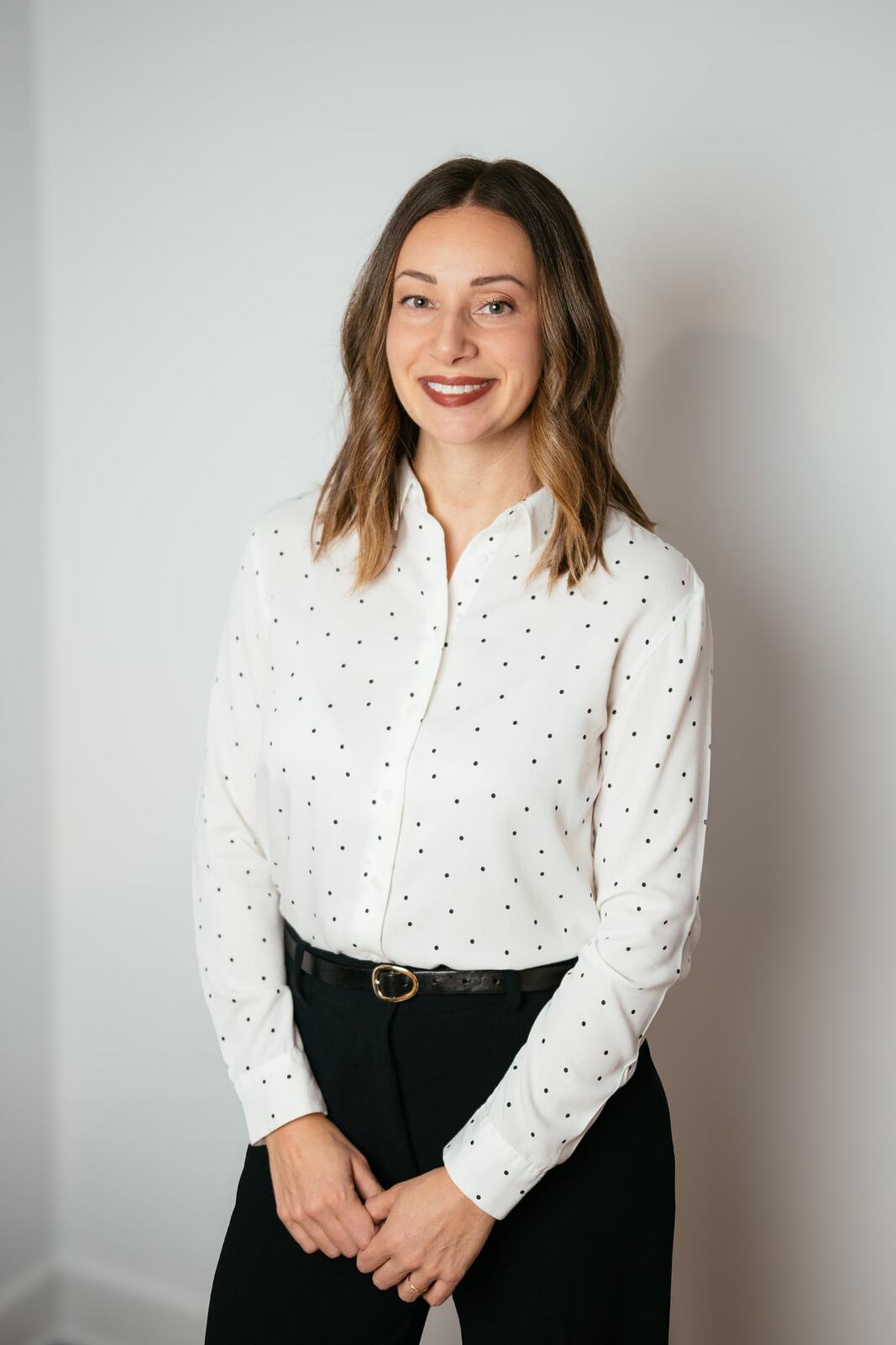 Beth standing with her hands together for an Ottawa headshot