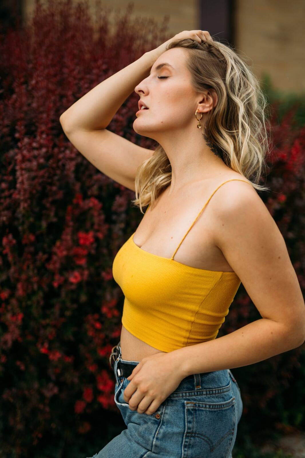Brittany in Yellow and Blue portraits story frame 5: A two-look Kelowna portrait story for Brittany, led by the yellow styling and dark green texture, then moving into blue lakeside frames and a soft rainbow-bokeh finish.
