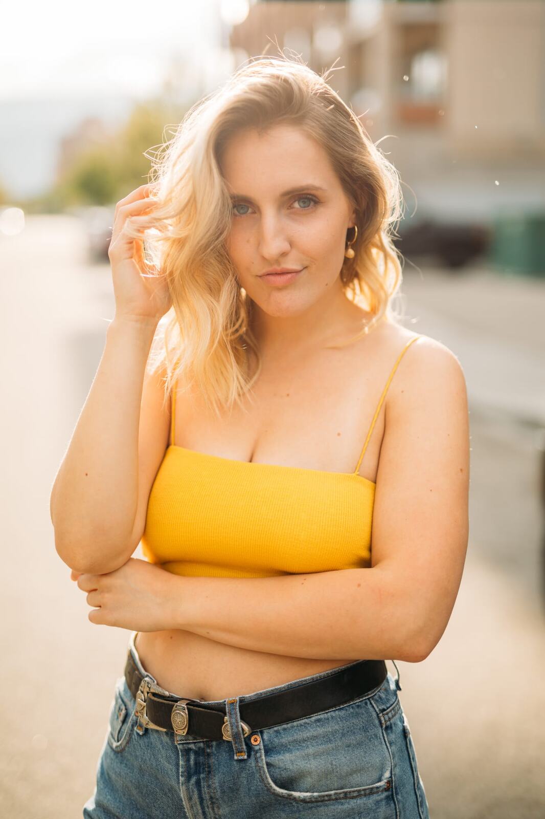 Brittany in Yellow and Blue portraits story frame 8: A two-look Kelowna portrait story for Brittany, led by the yellow styling and dark green texture, then moving into blue lakeside frames and a soft rainbow-bokeh finish.