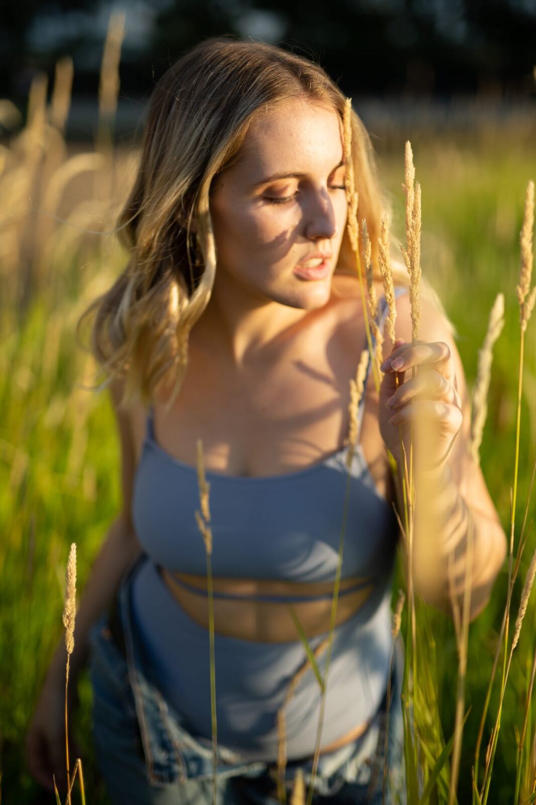 Brittany in Yellow and Blue portraits story frame 19: A two-look Kelowna portrait story for Brittany, led by the yellow styling and dark green texture, then moving into blue lakeside frames and a soft rainbow-bokeh finish.