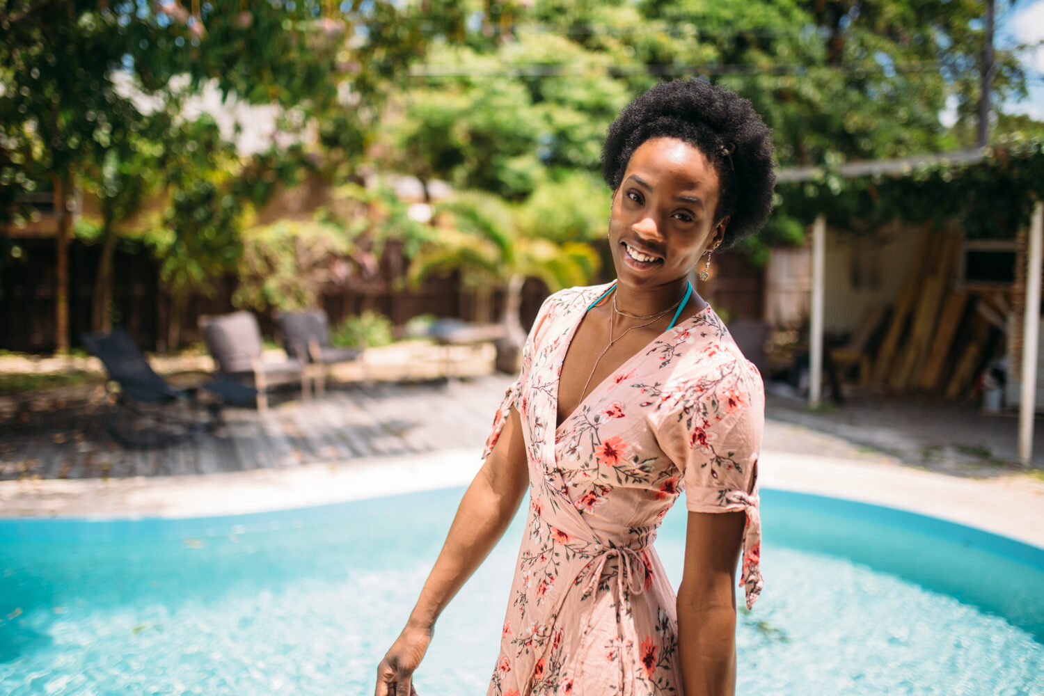 Dee-J smiling beside the pool in Miami