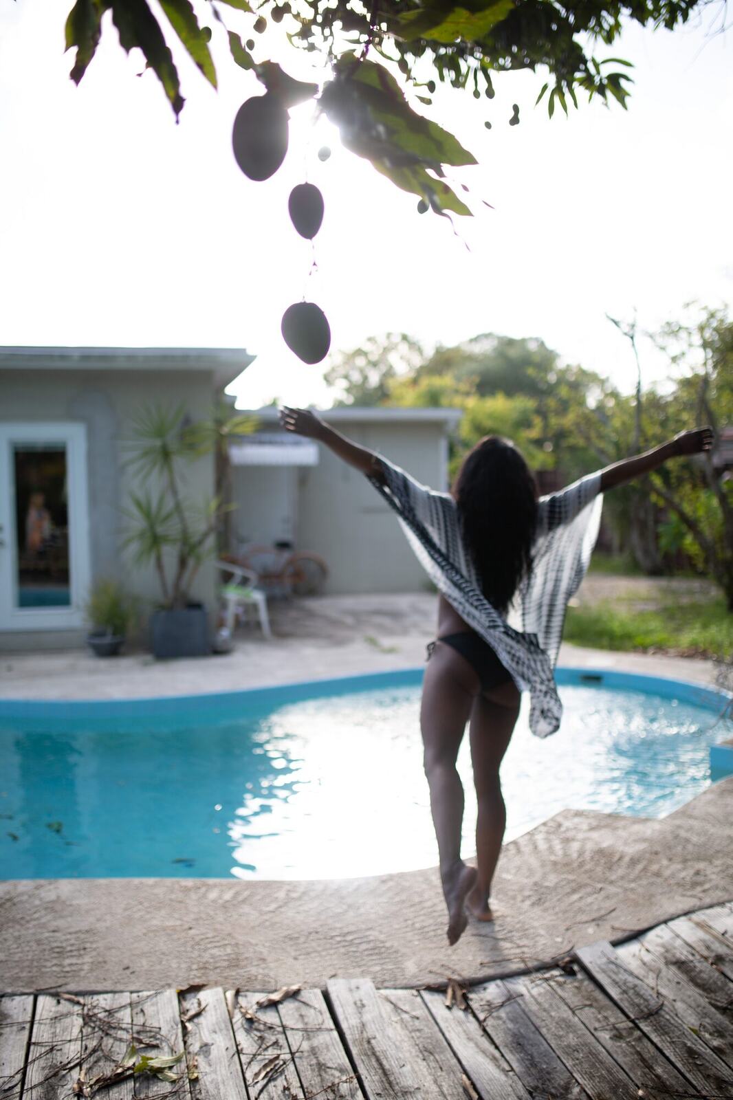 Dee-J in Miami portraits story frame 27: Two days with Dee-J in Miami, moving from a bright poolside portrait story to a second pool sequence and green-dress portraits along the riverbank.