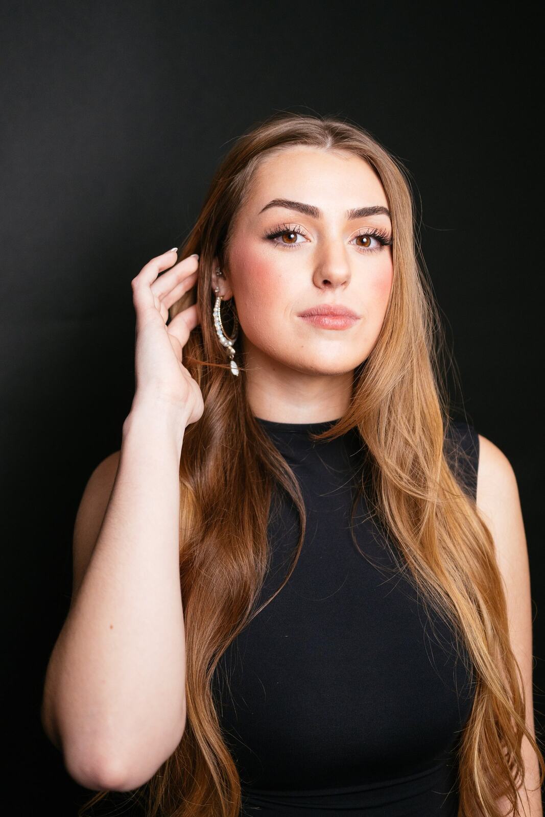 Bright, polished headshot of Elena on a black backdrop