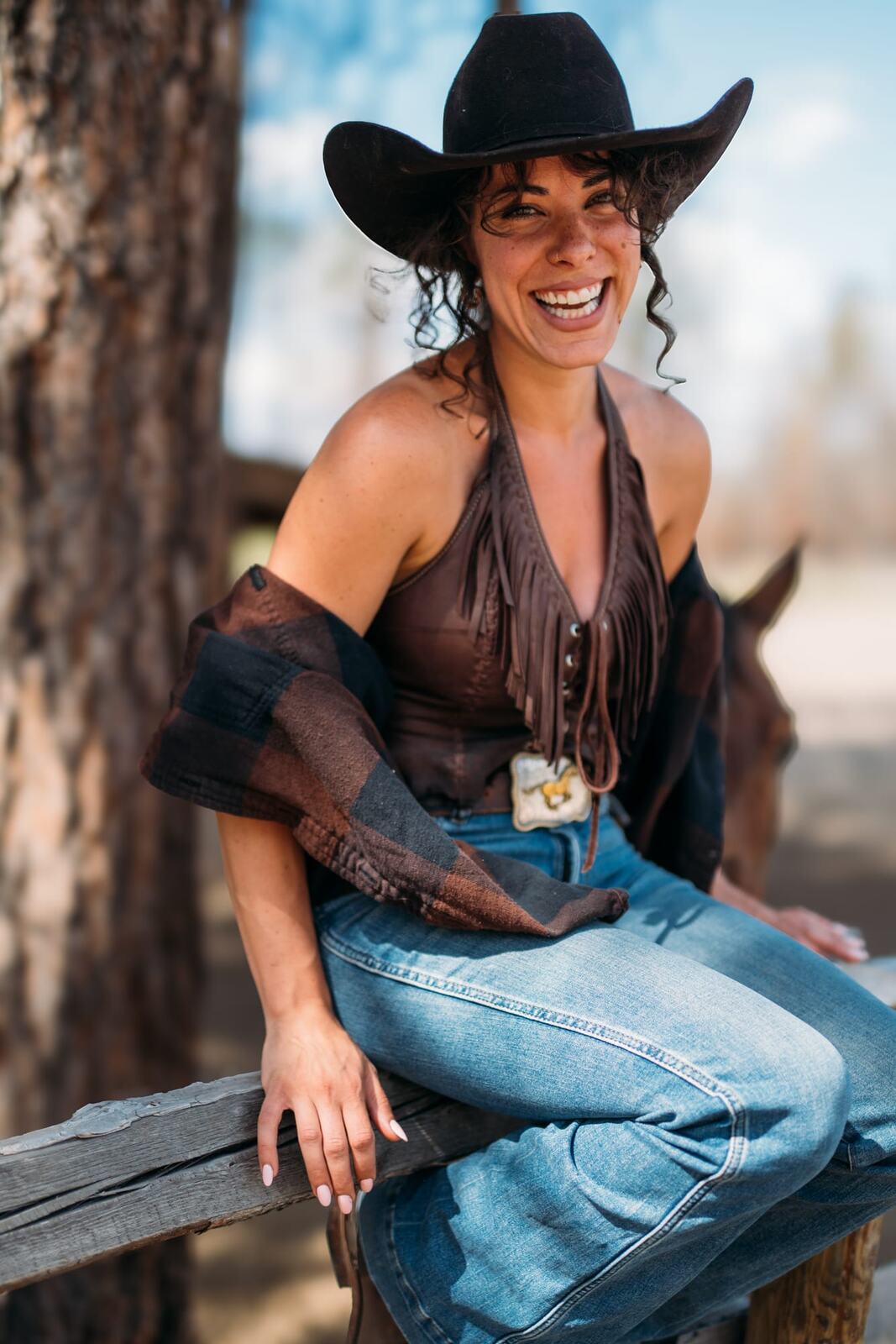 Giuliana at LoveReins portraits story frame 7: Equestrian portrait session at Love Reins Ranch in Lake Country, BC, with Giuliana, horses, white-dress portraits, Western cowgirl styling, ranch fencing, riding frames and warm Okanagan light..