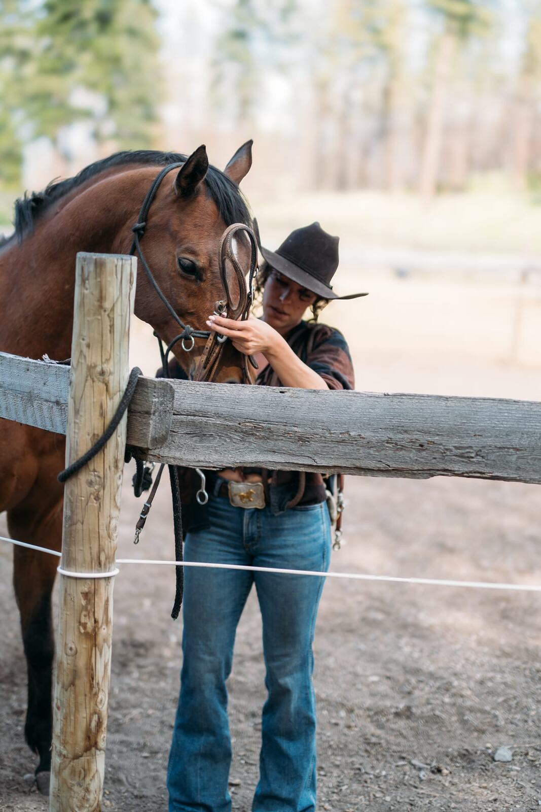 Giuliana at LoveReins portraits story frame 11: Equestrian portrait session at Love Reins Ranch in Lake Country, BC, with Giuliana, horses, white-dress portraits, Western cowgirl styling, ranch fencing, riding frames and warm Okanagan light..