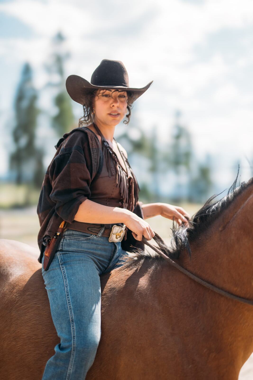Giuliana at LoveReins portraits story frame 13: Equestrian portrait session at Love Reins Ranch in Lake Country, BC, with Giuliana, horses, white-dress portraits, Western cowgirl styling, ranch fencing, riding frames and warm Okanagan light..
