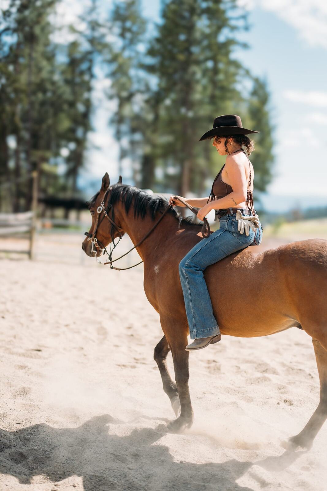 Giuliana at LoveReins portraits story frame 15: Equestrian portrait session at Love Reins Ranch in Lake Country, BC, with Giuliana, horses, white-dress portraits, Western cowgirl styling, ranch fencing, riding frames and warm Okanagan light..