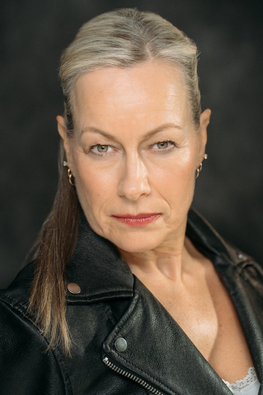 Shaye in a leather jacket with a direct expression