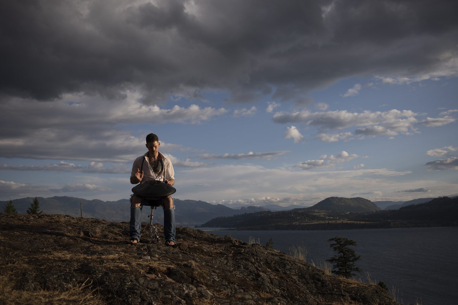 Jacob framed small against the open hillside, sky and lake.