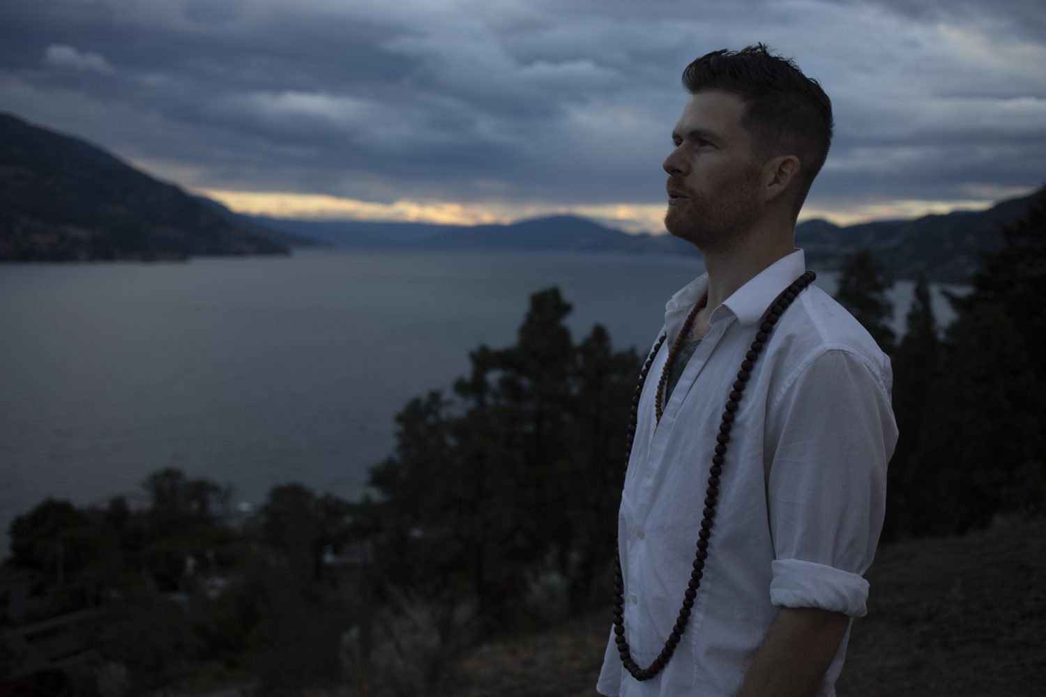 A dusk side-profile portrait of Jacob above the lake.