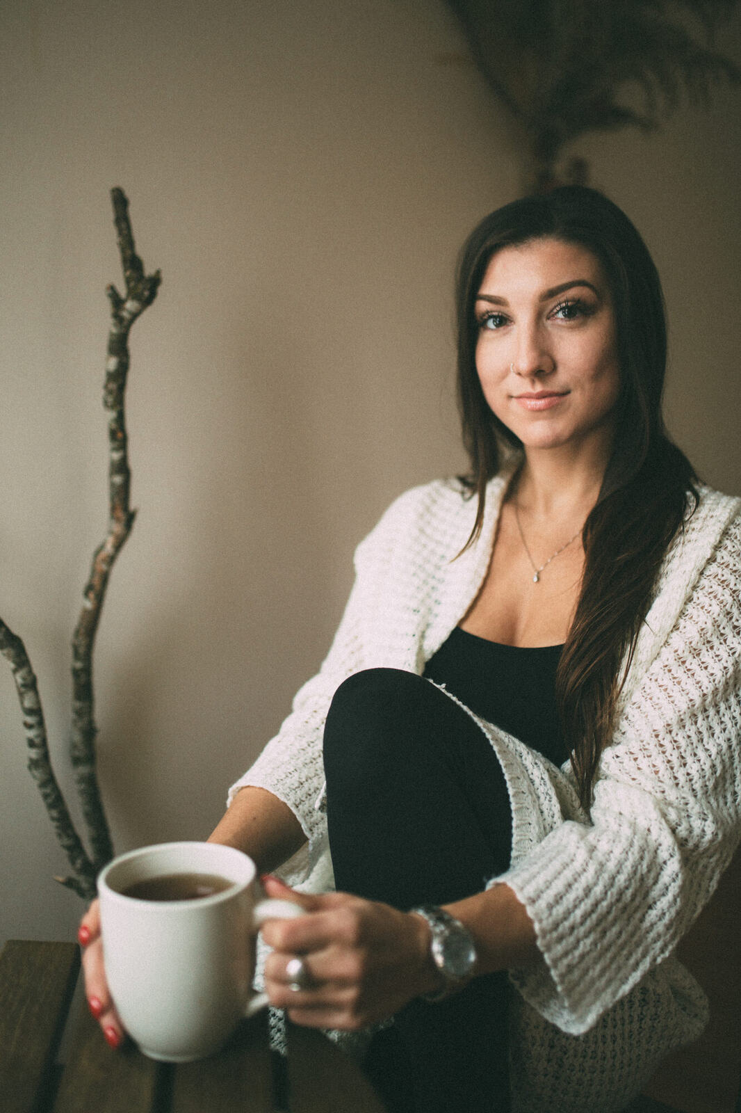 Jasmin by the Window portrait story frame 4: Window-light portraits with Jasmin beside a small table, tea and winter greenery in Kelowna, British Columbia.