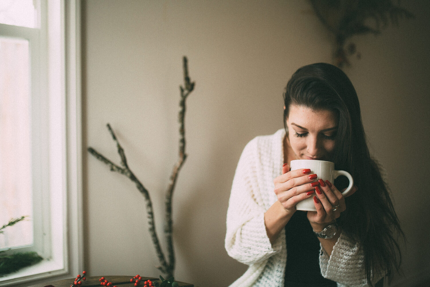Jasmin by the Window portrait story frame 10: Window-light portraits with Jasmin beside a small table, tea and winter greenery in Kelowna, British Columbia.