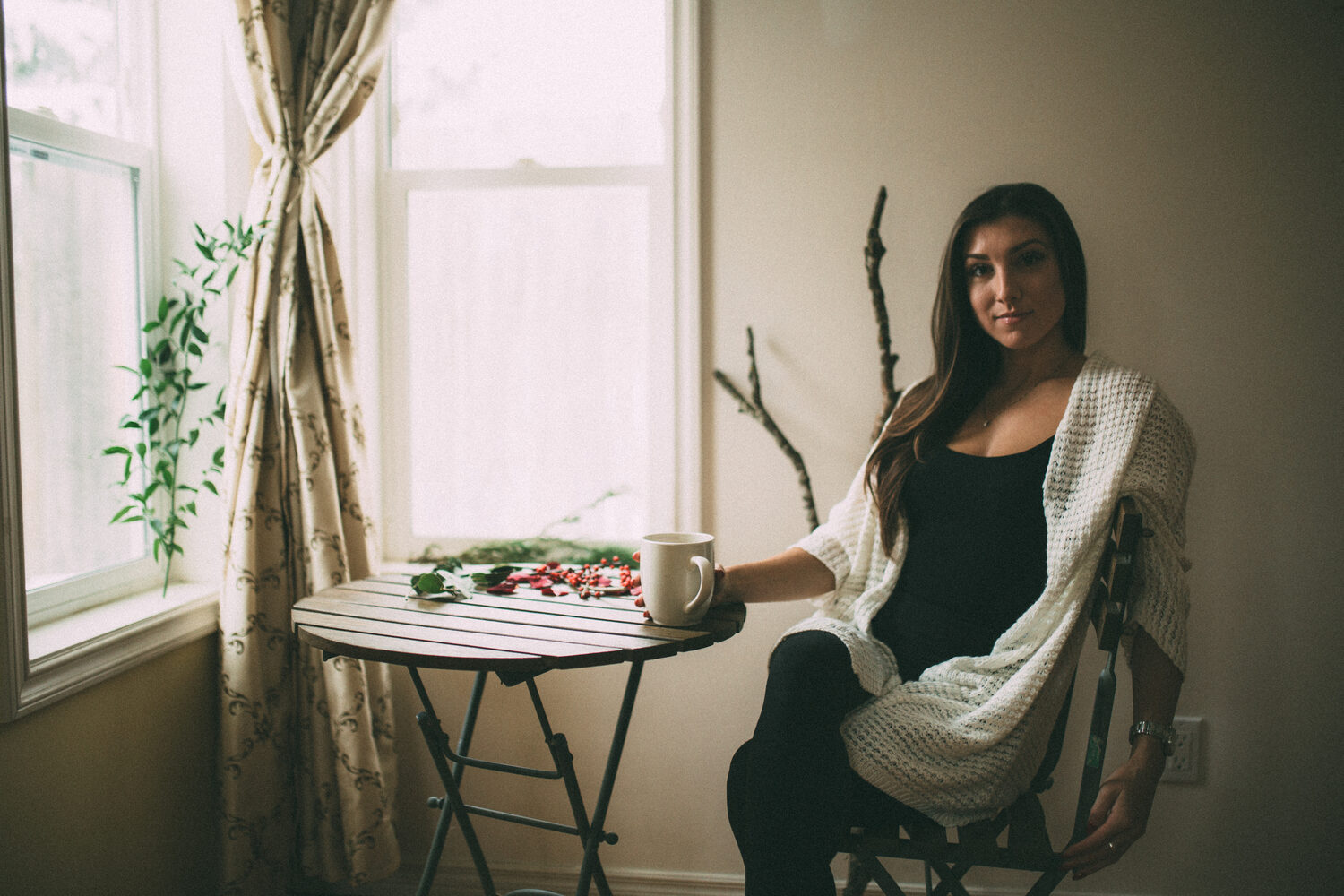 Jasmin by the Window portrait story frame 14: Window-light portraits with Jasmin beside a small table, tea and winter greenery in Kelowna, British Columbia.