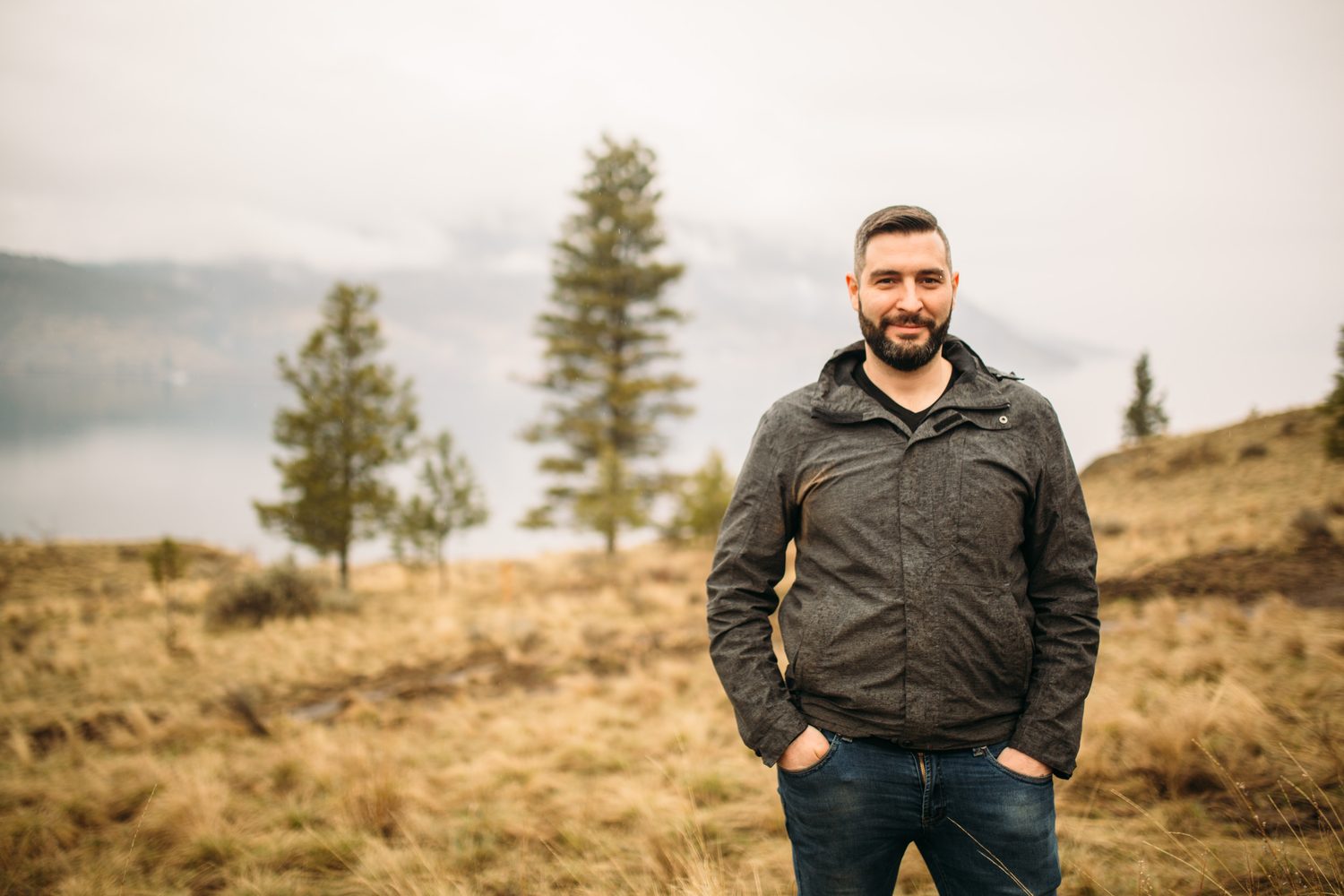 Jeremy standing in warm hillside light in a dark blazer for Optimize Organics.