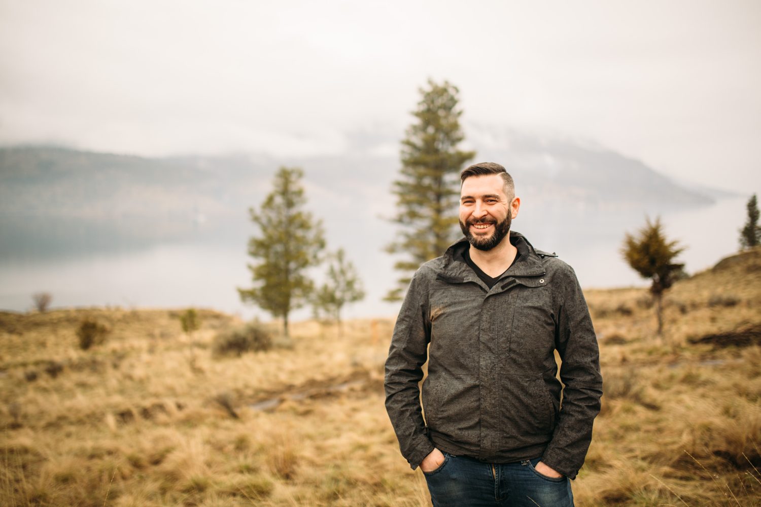 Jeremy standing in warm hillside light in a dark blazer for Optimize Organics.