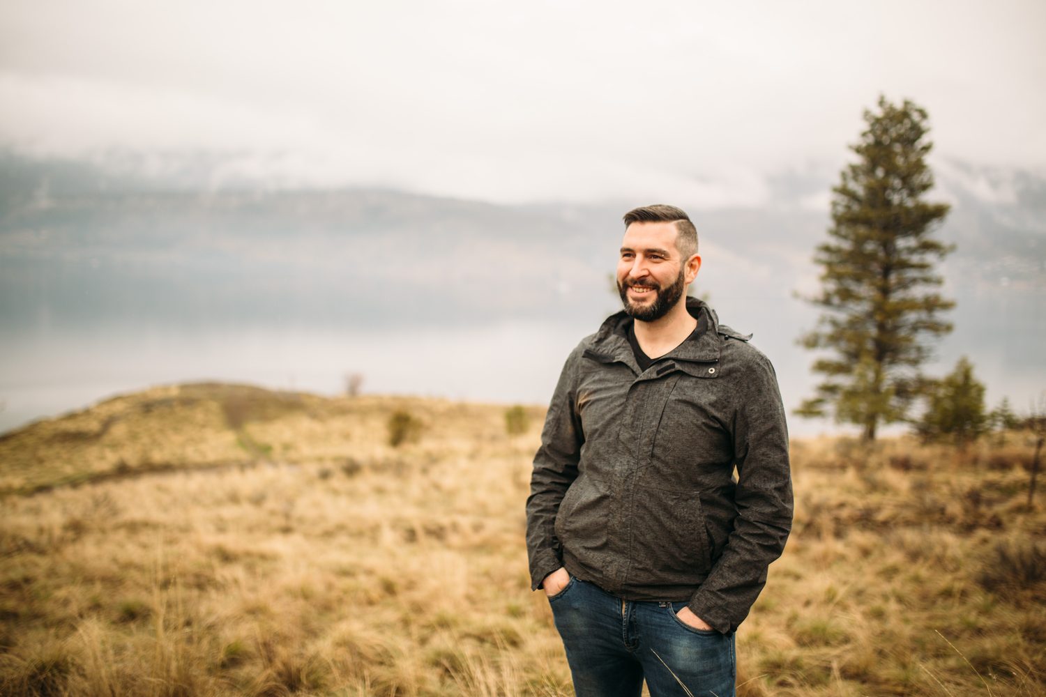 Jeremy standing in warm hillside light in a dark blazer for Optimize Organics.