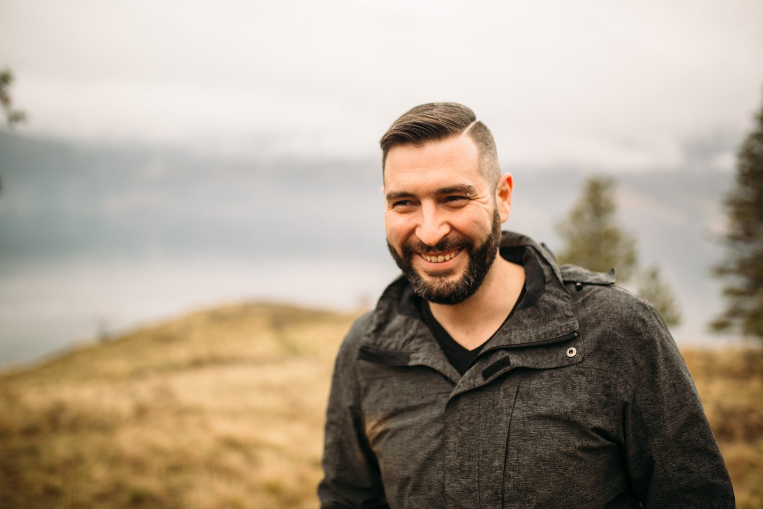 Jeremy standing in warm hillside light in a dark blazer for Optimize Organics.
