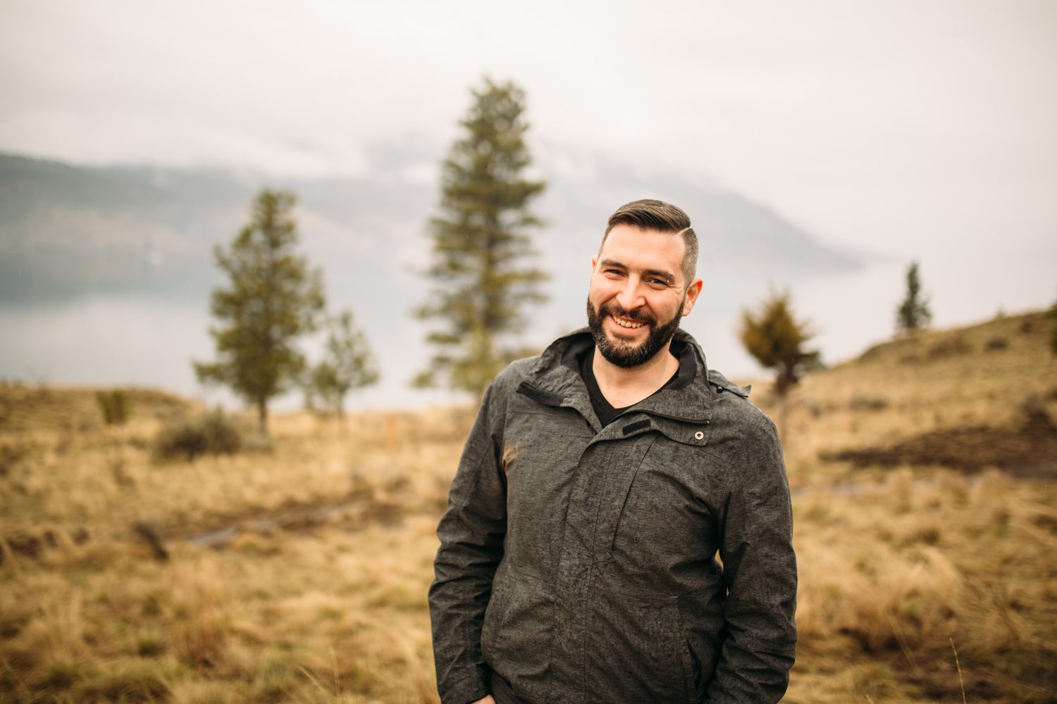 Jeremy standing in warm hillside light in a dark blazer for Optimize Organics.