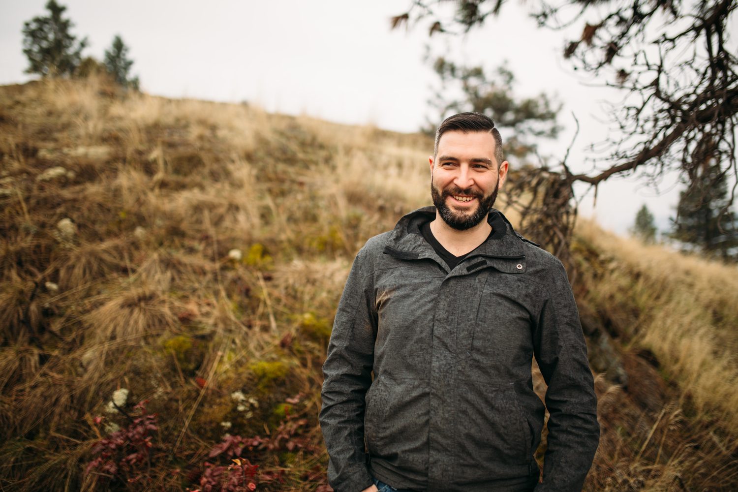 Jeremy standing in warm hillside light in a dark blazer for Optimize Organics.