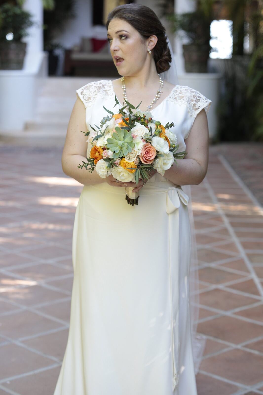Kyra holding her tropical bouquet before the beach ceremony