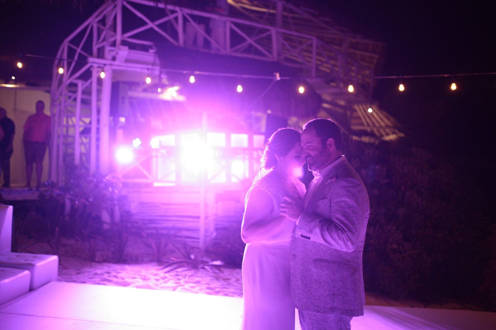 Kyra and Ted dancing together beneath the reception lights