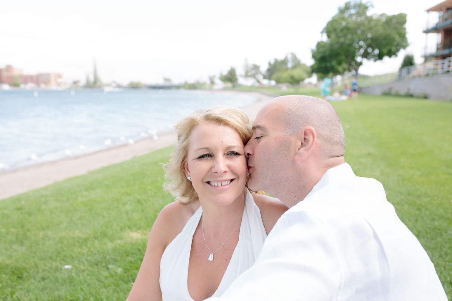 Leeanne and Kelly weddings story frame 4: A Watermark Beach Resort wedding in Osoyoos, built around lakefront context, grown-family connection and careful, big-hearted coverage..