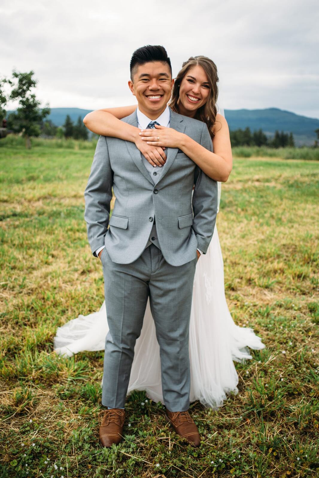 Leslie and Gerome weddings story frame 4: A Brook & Barn - Casorso Heritage Farm wedding in Kelowna, with orchard details, outbuildings, lawn games and a familiar friend-party feeling..