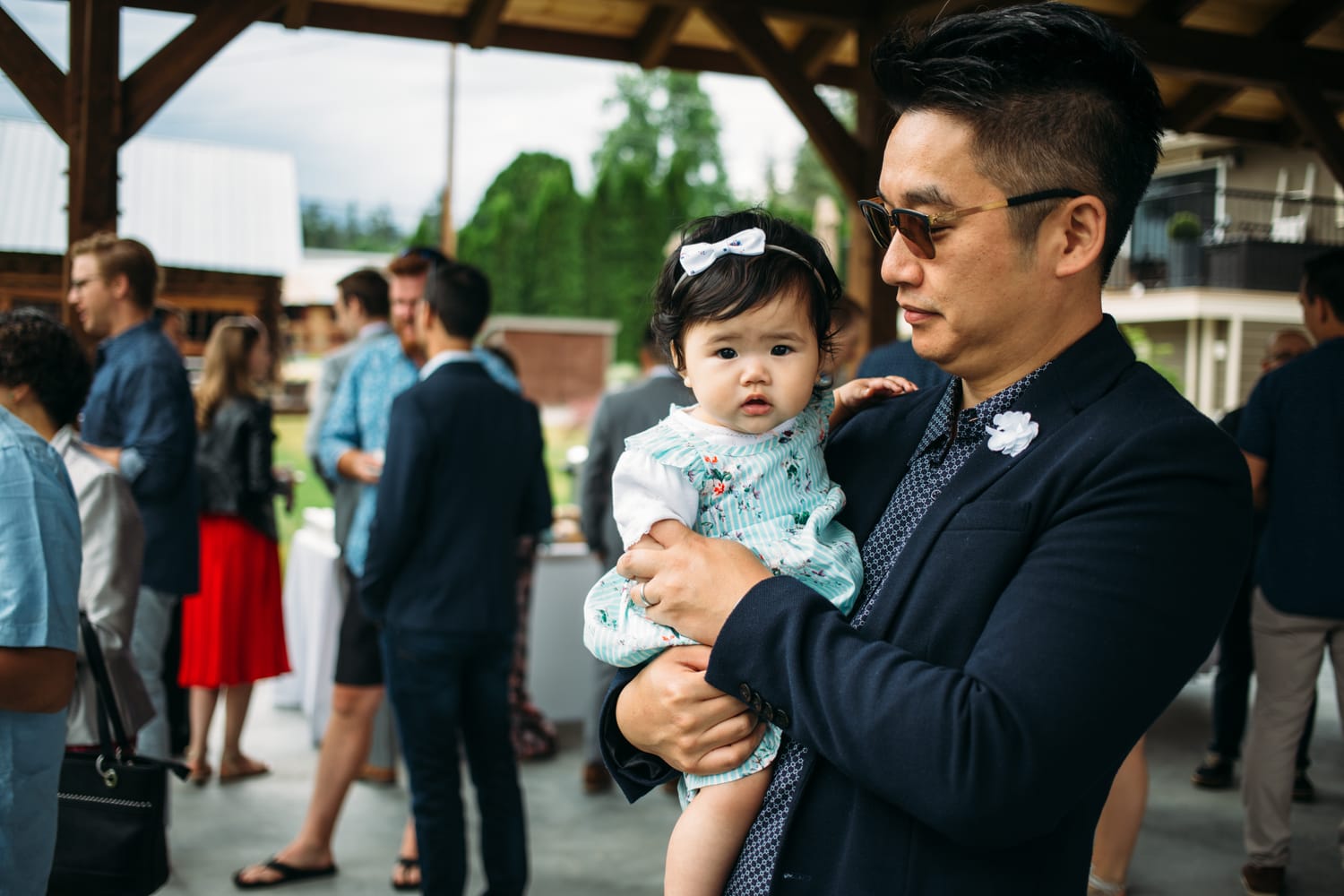 Leslie and Gerome weddings story frame 9: A Brook & Barn - Casorso Heritage Farm wedding in Kelowna, with orchard details, outbuildings, lawn games and a familiar friend-party feeling..