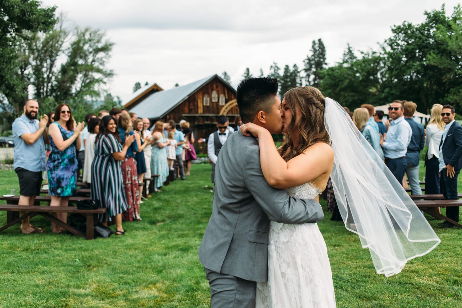 Leslie and Gerome weddings story frame 16: A Brook & Barn - Casorso Heritage Farm wedding in Kelowna, with orchard details, outbuildings, lawn games and a familiar friend-party feeling..