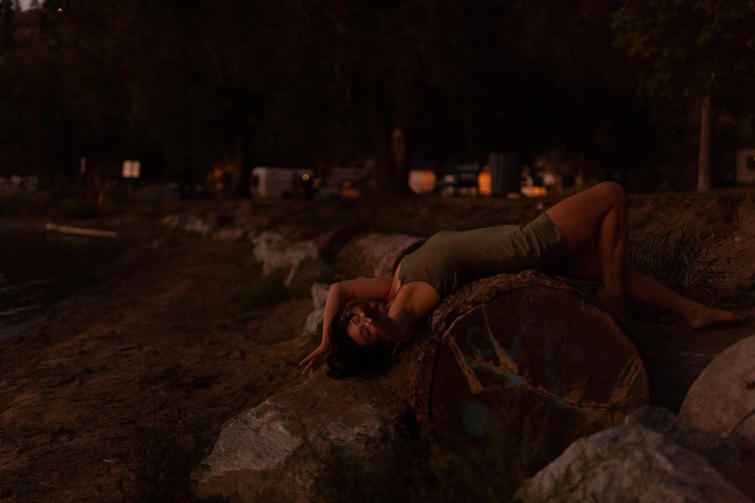 Lucy at the Water’s Edge portraits story frame 8: Lucy at the water’s edge as sunset slips into moonlight, moving from the shoreline and rocks to quiet close portraits and a warm-lit garden after dark. Photographed in Kelowna, BC.