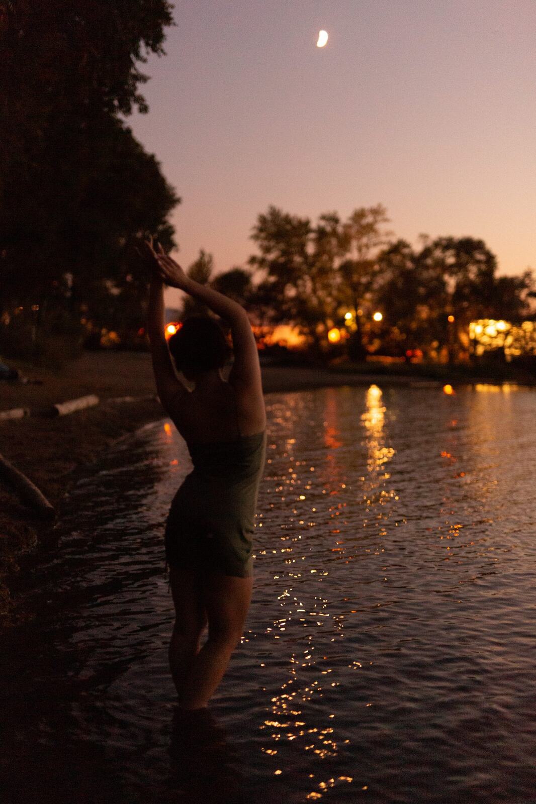 Lucy at the Water’s Edge portraits story frame 20: Lucy at the water’s edge as sunset slips into moonlight, moving from the shoreline and rocks to quiet close portraits and a warm-lit garden after dark. Photographed in Kelowna, BC.