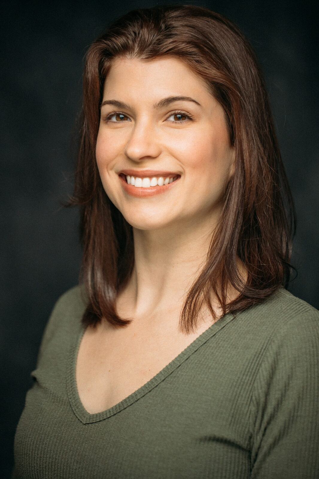 Marie smiling in a green sweater headshot