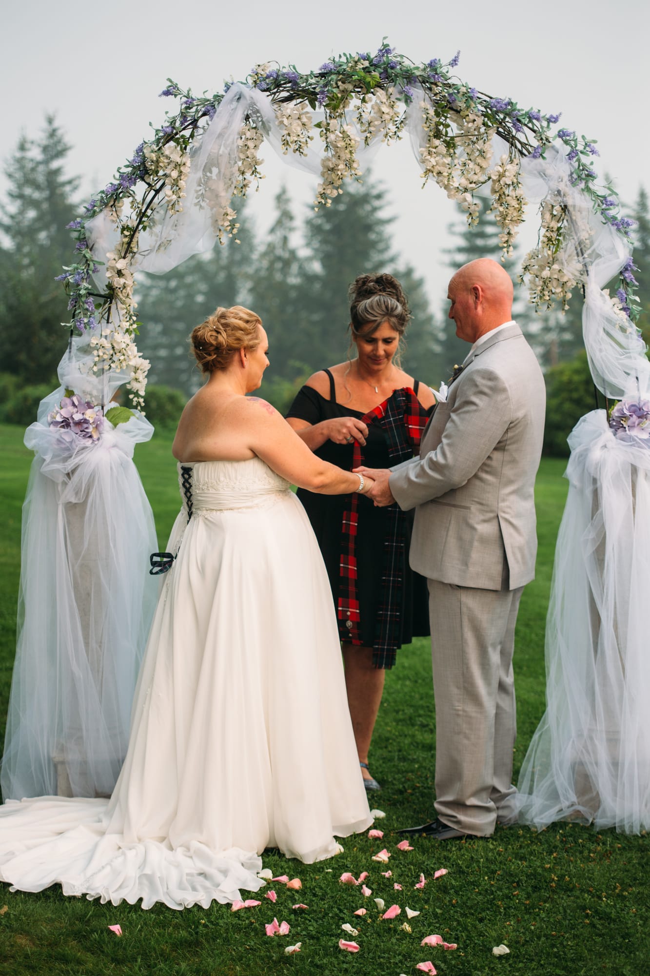 Marie and Mark weddings story frame 16: A Mabel Lake Airpark wedding in the North Okanagan, with grass-runway scenery, open-air photos and sweet family help around makeup, flowers and petals..