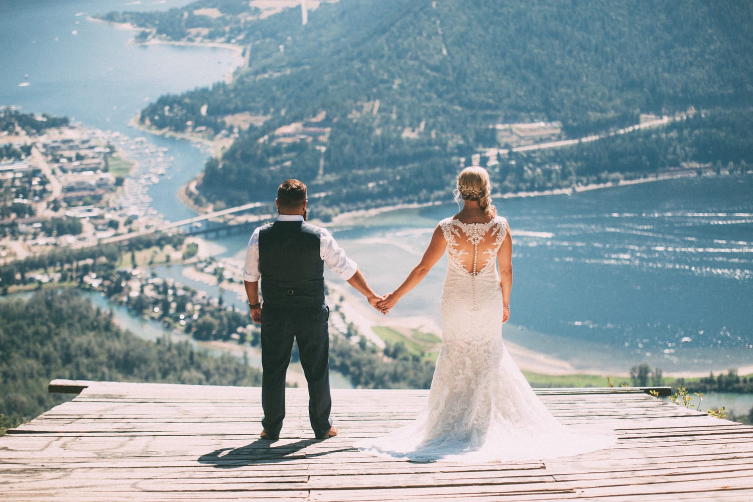 Megan and Jarid weddings story frame 9: A Shuswap-area wedding around Sicamous, Swansea Point and Hyde Mountain, with boat/lake context, cliff portraits and strong floral colour..