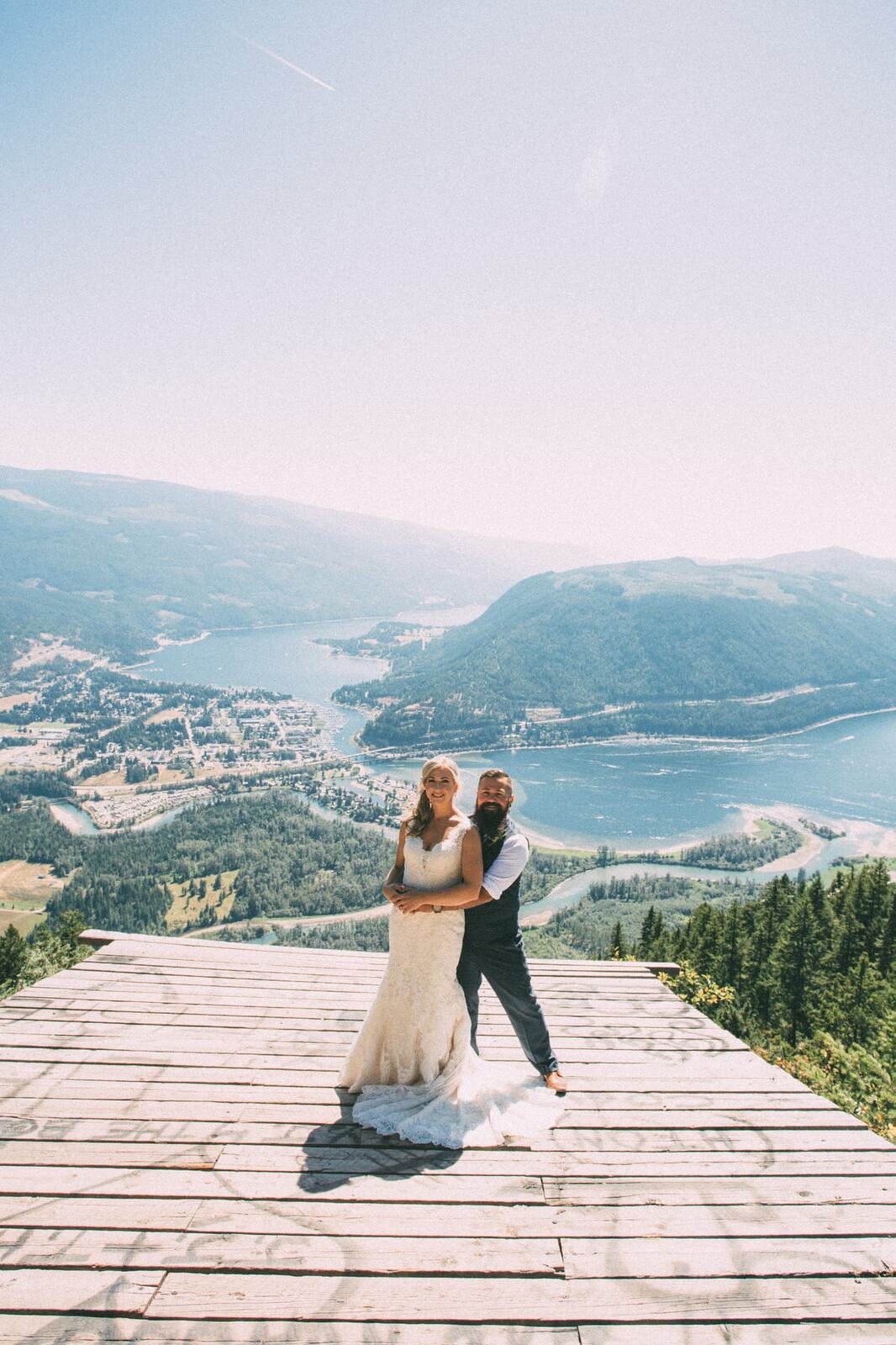 Megan and Jarid weddings story frame 10: A Shuswap-area wedding around Sicamous, Swansea Point and Hyde Mountain, with boat/lake context, cliff portraits and strong floral colour..