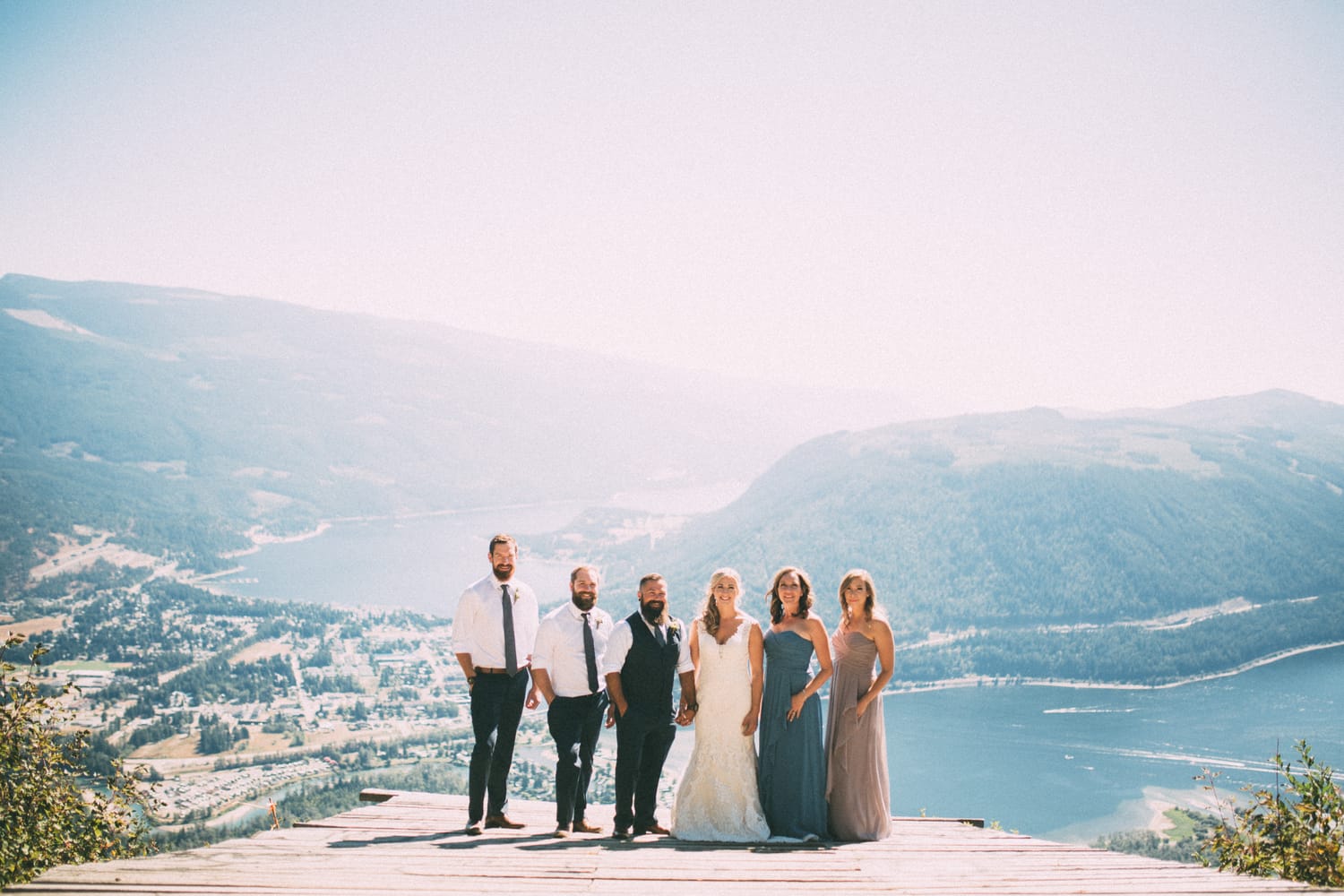 Megan and Jarid weddings story frame 12: A Shuswap-area wedding around Sicamous, Swansea Point and Hyde Mountain, with boat/lake context, cliff portraits and strong floral colour..