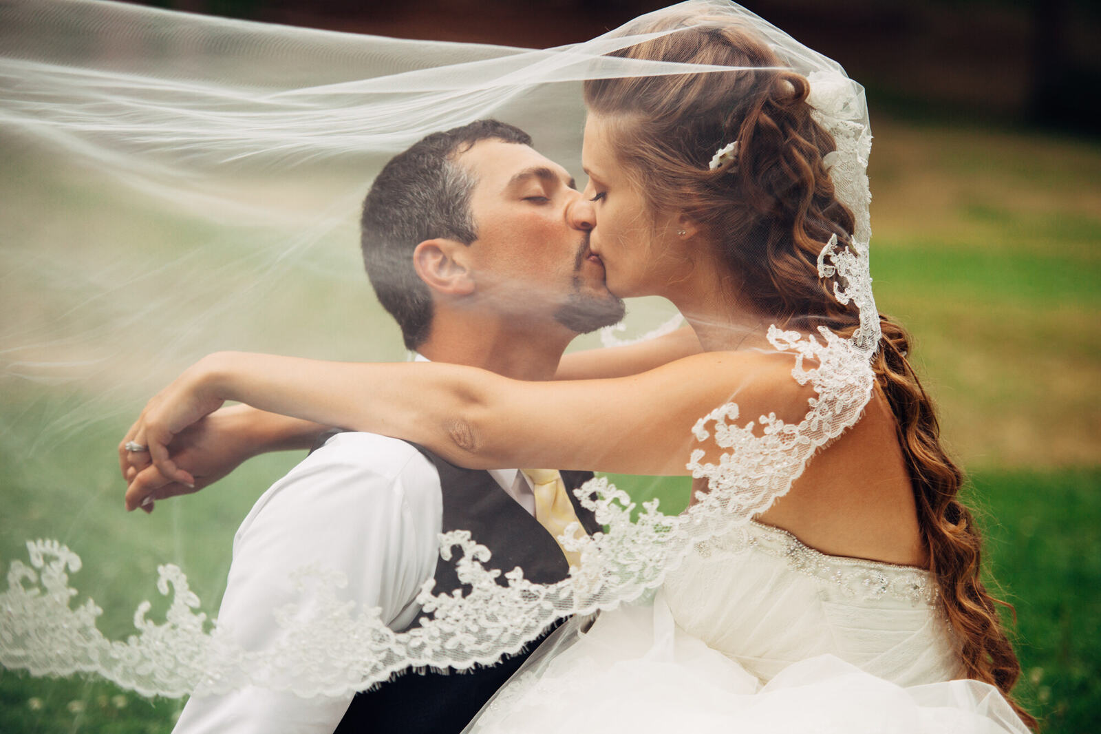 Mel and Blaise kissing beneath a wind-lifted veil in Blind Bay