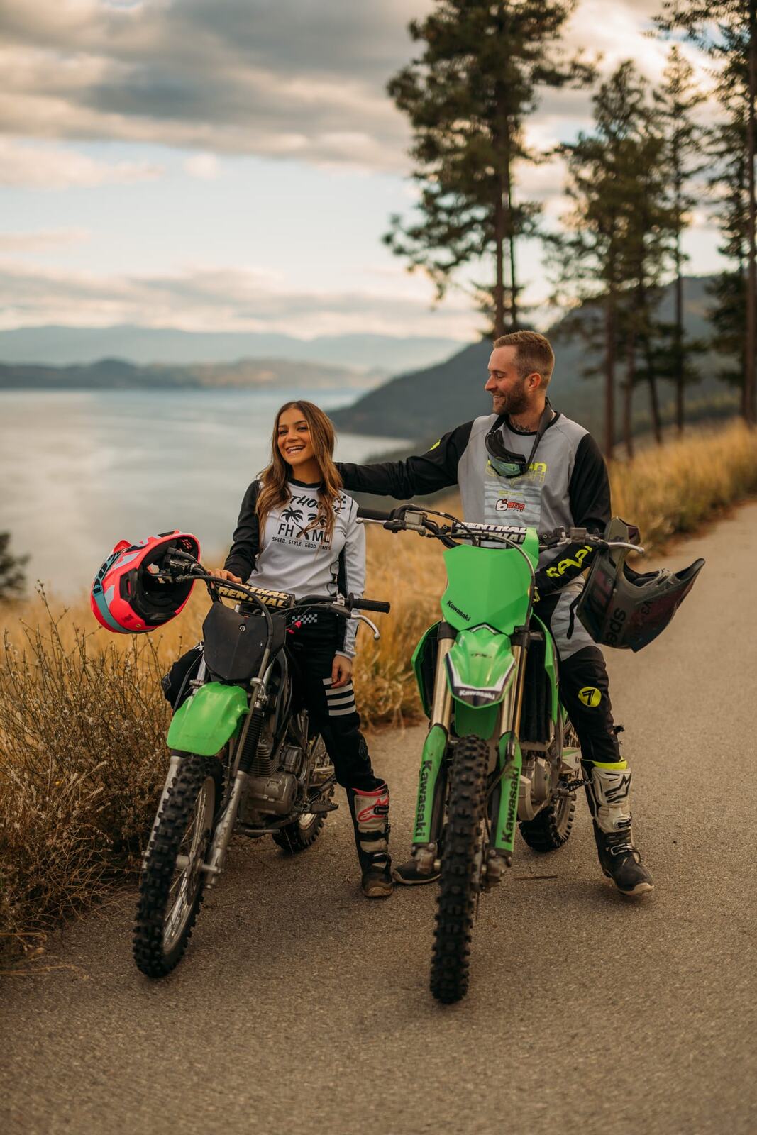 Rachel and Ryan portraits story frame 3: Okanagan couples portraits with dirt bikes, lake and mountain views, autumn sun, standing portraits and champagne celebration.
