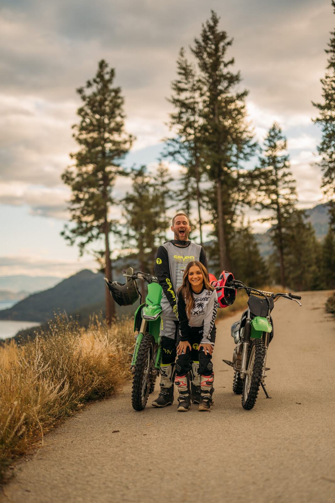 Rachel and Ryan portraits story frame 5: Okanagan couples portraits with dirt bikes, lake and mountain views, autumn sun, standing portraits and champagne celebration.